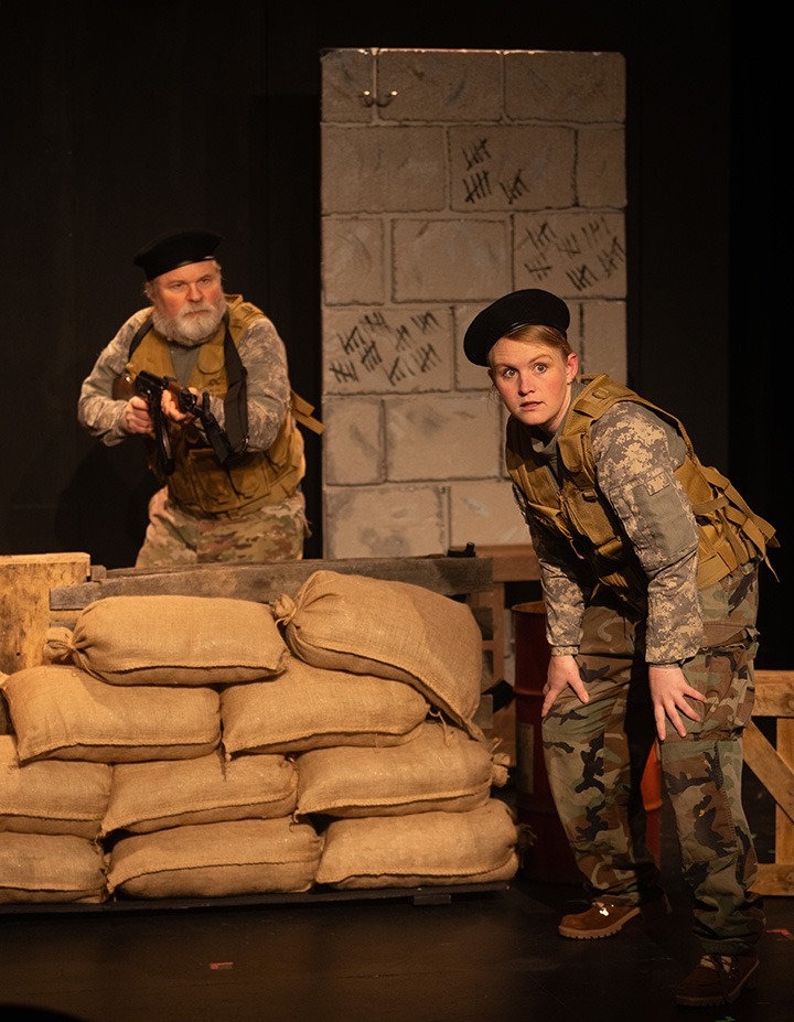 Ward in military gear with a gun and a female solider.